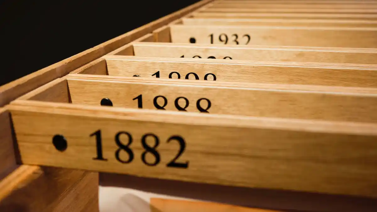 A wooden crate with wooden filing dividers which have dates printed on them. The first date is eighteen eighty two.